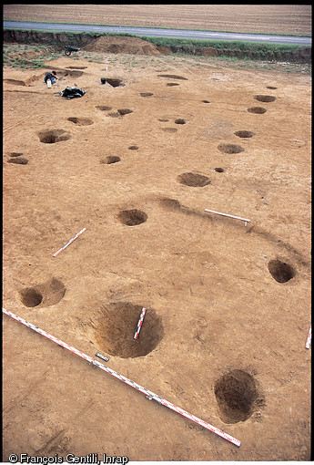 Vestige d'un bâtiment sur poteaux plantés, VIIIe s. de notre ère, Serris (Seine-et-Marne), 1992.  Ce bâtiment, dont le plan est révélé par l'emplacement des trous de poteaux, fait partie d'un grand habitat rural mérovingien. 