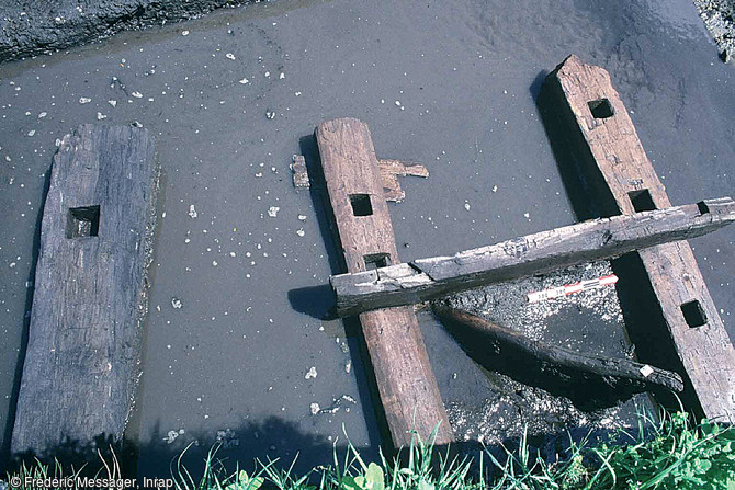 Poutres en orne et en chêne assemblées par tenons et mortaises, formant une passerelle permettant de franchir le fossé en direction du sud, seconde moitié du XIe s., Pineuilh (Gironde), 2003.