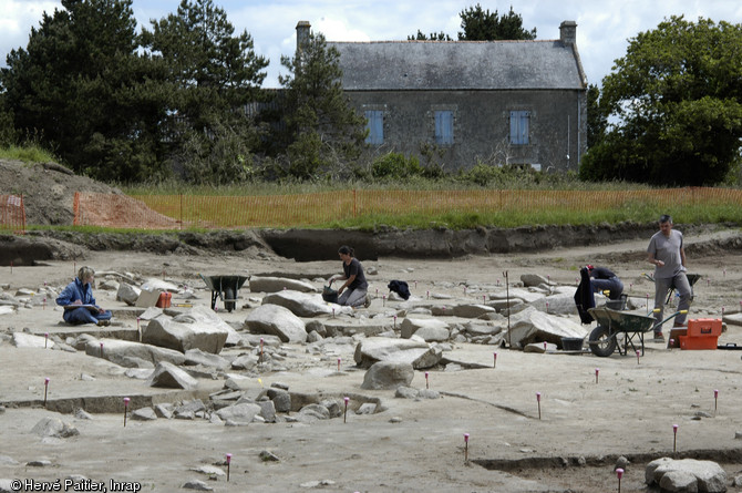 Champ de menhirs brisés en cours de fouille à Kerdruellan (Morbihan), 2006.  La fouille a démontré que l’abattage des menhirs est antérieur à la fin du Néolithique : un niveau de circulation, sur lequel un corpus céramique et lithique attribuable au IIIe millénaire avant notre ère a été mis au jour, scelle pour partie les blocs déjà couchés. 