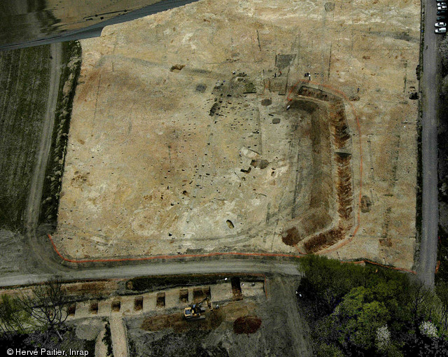 Vue aérienne d'une exploitation agricole gauloise à Parville (Eure), IIe-Ier s. avant notre ère. Fouille du Bois de Parville, 2006.  Au sein d'un vaste enclos, l'exploitation s'organise autour de divers bâtiments à fonction domestique et agricole. Cet enclos est délimité par un fossé aux dimensions remarquables (380 m de périmètre, large de 3 m et profond de 1,40 m). 