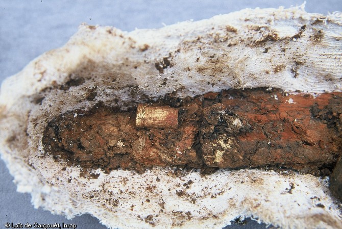 Scramasaxe (coutelas à un seul tranchant) en cours de restauration, retrouvé en 2002 dans une tombe aristocratique, Saint-Dizier (Haute-Marne) datée des années 525-550.  Son fourreau en bois d’aulne recouvert de cuir, devait comporter une poche dans laquelle était glissé en couteau en fer dont on aperçoit la poignée en or. 