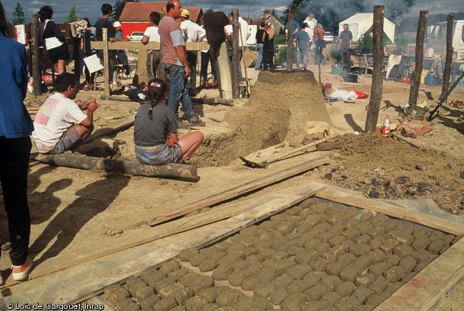 Reconstitution expérimentale de bas fourneaux protohistoriques organisée en juillet 1997 à la suite de la découverte de nombreux bas fourneaux sur l'emprise de l'autoroute A28 dans le secteur du Mans.  Au premier plan, on peut voir des briques d'argile crue façonnées pour fabriquer les fours.