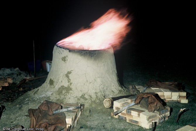 Bas fourneau réalisé dans le cadre d'une journée d'expérimentation de la métallurgie du fer en novembre 1999 à Montargis (Loiret).  Le four est ici en phase de préchauffage et la combustion se fait par ventilation naturelle. 