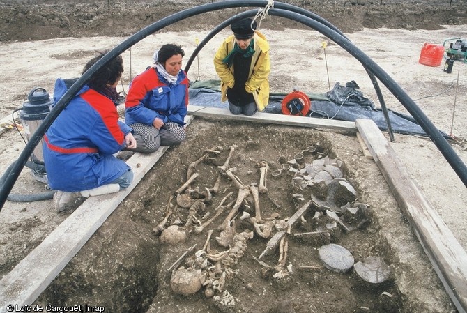 Fouille d'une tombe à char datant du IVe siècle avant notre ère, Reims, 2001. On distingue une épée et de la vaisselle en céramique déposées auprès des corps des défunts.