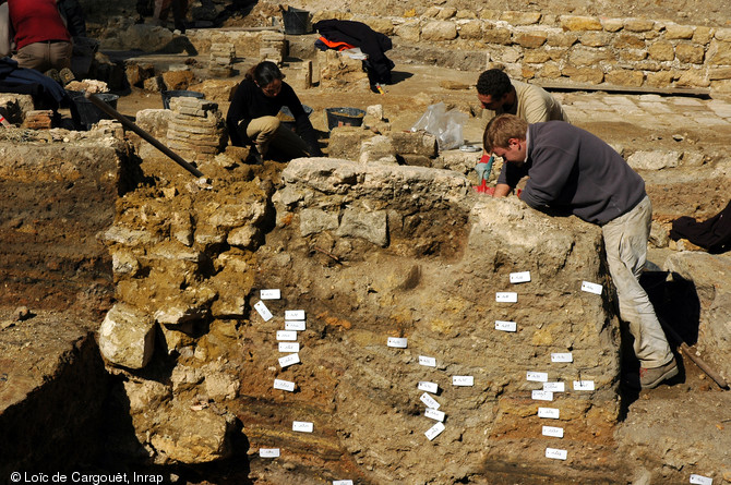 Fouille de maisons du Haut-Empire, Institut Curie, Paris, 2006.  Au premier plan, berme-témoin de la stratification des différents niveaux archéologiques. Au second plan à gauche, on peut observer les pilettes d'hypocauste constituant le système de chauffage d'une des pièces de la maison. 