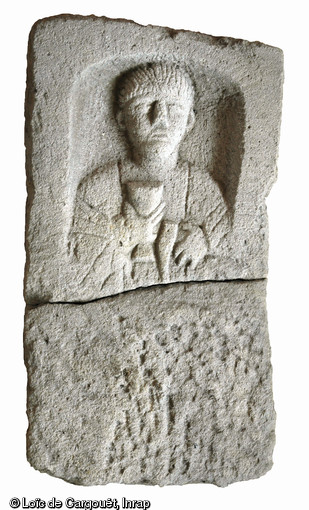 Stèle funéraire gallo-romaine n° 81 en arkose (hauteur 74 cm, largeur 43 cm), nécropole de Pont-L'Évêque, Autun (Saône-et-Loire), 2004.  La tête de ce personnage en buste a été sculptée avec soin, lui donnant une expression sévère. Sa main droite tient un grand gobelet à pied, tandis que la main gauche est fermée sur le manche d'un marteau : ce dernier attribut laisse penser que le défunt était un sculpteur de pierre ou un artisan du fer. 