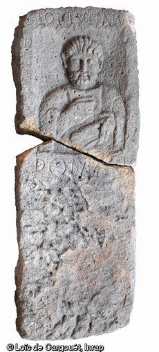 Stèle funéraire gallo-romaine en arkose (hauteur 180 cm, largeur 49 cm), première moitié du IIe s. de notre ère, nécropole de Pont-L'Évêque, Autun (Saône-et-Loire), 2004.  La stèle figure un personnage masculin : la main droite levée tient un gobelet ; la gauche tient un grand ciseau à larges lames plates qui peut être utilisé entre autres pour le travail de la laine. L'inscription précise : Lollianu(s), D(iis) M(anibus). Domi [f(ilius)], « Aux dieux Mânes. (Ci-gît) Lollianus, fils de Domus .