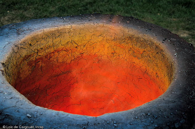 Détail de la  gueule  d'un bas fourneau en activité lors d'une reconstitution expérimentale de fours protohistoriques de réduction du minerai de fer en juillet 1997 près du Mans (Sarthe).   Cette expérimentation a été effectuée à l'occasion de la fouille de sites sidérurgiques entre 1996 et 1997 sur l'emprise de l'autoroute A28.  