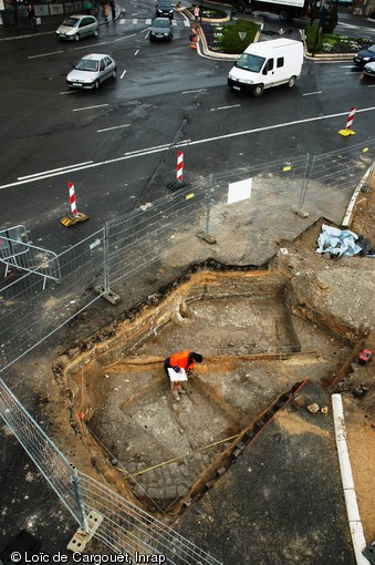 Vue générale de la tranchée de diagnostic effectuée près de la porte de Mars à Reims entre juillet 2007 et novembre 2008. L'opération a révélé un tronçon du cardo (axe nord-sud de la ville) passant sous l'arc principal et présentant un état ancien daté du courant du IIe s. de notre ère et un récent contemporain à l'aménagement de la porte de Mars.