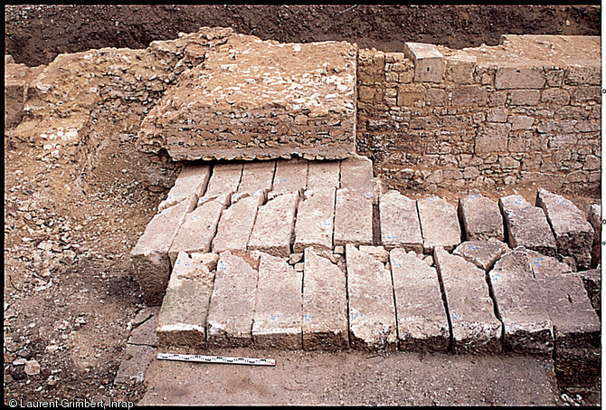 Enceinte de Saintes (Charente-Maritime), datée de l'Antiquité tardive (IVème siècle de notre ère) et éléments de fondation d'une tour datée du Haut Moyen-Âge et fouillée en 2000.   Au premier plan, la partie inférieure de la fondation comporte ici des éléments de corniches disposés en vis-à-vis. Au second plan, on aperçoit la fondation de la tour du haut Moyen-Âge venue compléter ultérieurement le dispositif défensif.