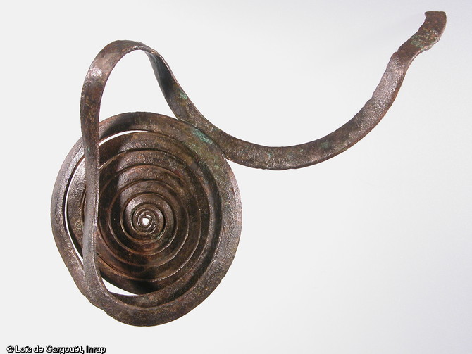 Spirale de jambière en bronze à spires en ruban chevauchantes provenant d'une sépulture de l'âge du Bronze de la nécropole  du Petit Moulin  (Yonne), 2004.