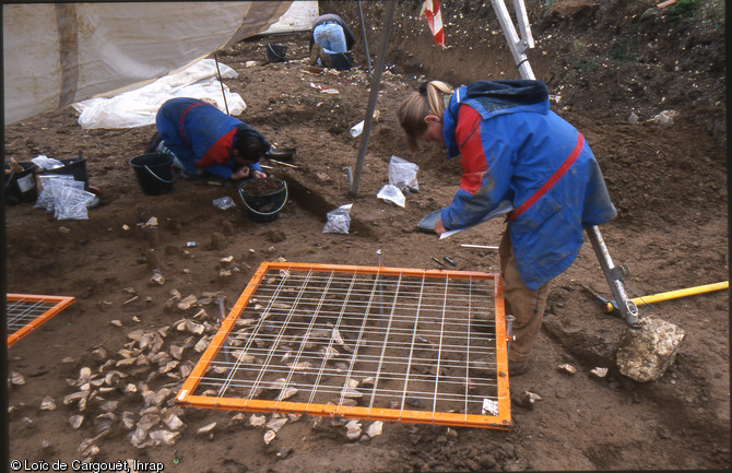 Enregistrement par carroyage et relevé de l'un des ateliers de taille du campement mésolithique final de La Presle à Lhéry (Marne), 2001.  La fouille fine a permis de dégager des milliers de fragments de silex. 