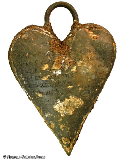 Cœur en plomb retrouvé sur le cercueil de Louise de Quengo, dame de Brefeillac, découvert au couvent des Jacobins à Rennes (Ille-et-Vilaine), 2015. L’identification du corps a été rendue possible grâce aux inscriptions sur le reliquaire en plomb.