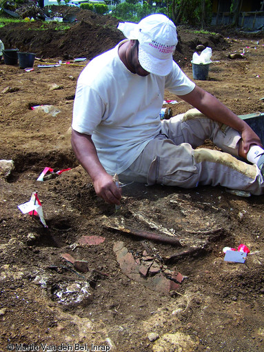 Sépulture amérindienne en cours de fouille découverte à Trois-Rivières (Guadeloupe), 2008.  L'individu repose en position semi-assise, les avant-bras sont pliés sur le ventre, les jambes hyperfléchies sur les bras. Une jatte en terre cuite est déposée sur le mort. Le crâne a chuté, ce qui indique la création d'espaces vides au cours de la décomposition et incite à, penser que l'individu a été enterré dans un contenant en matière périssable, probablement un hamac. 