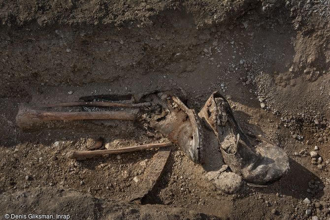 Paire de bottes avec des tibias découverte au cimetière militaire allemand de la Grande Guerre de Boult-sur-Suippe, Marne (2016).