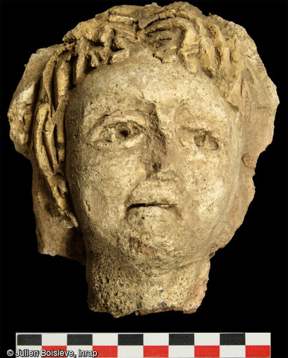 Tête d’un personnage aux cheveux blonds qui ornait un caisson du plafond stuqué découvert à Entrains-sur-Nohain (Bourgogne).
