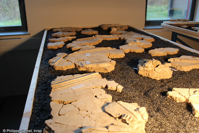 Fragments de stucs retrouvés à Entrains-sur-Nohain (Bourgogne). Les plaques de stuc sont assemblées dans des bacs à sable qui permettent de maintenir les remontages.