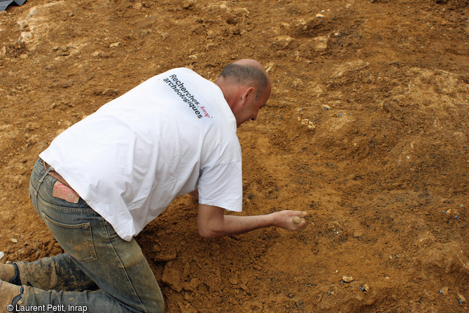 Archéologue dégageant une concentration de silex taillés sur le site du Paléolithique moyen récent (entre 110 000 et 70 000 ans) à Tigery (Essonne), 2016