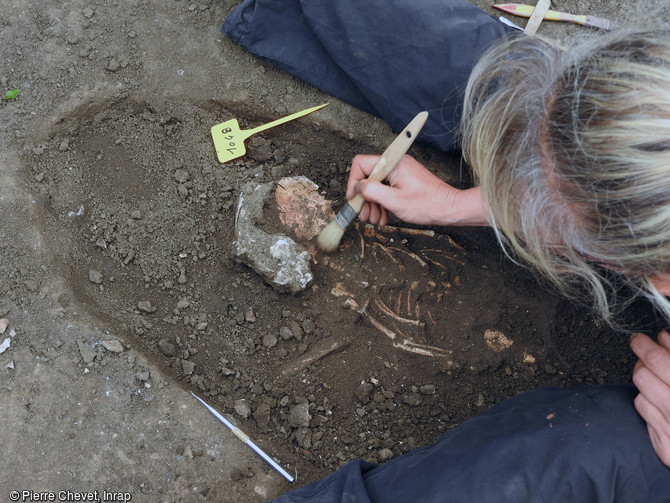 Dégagement d'un squelette de nouveau né du cimetière protestant du début de l'Époque moderne, sur site de la Visitation au Mans (Sarthe), 2016.