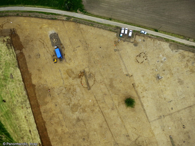 Vue aérienne de l'enclos gaulois et d'un cercle funéraire de l'âge du Bronze à Cléon (Seine-Maritime), 2016. A l'intérieur de l'enclos on distingue un bâtiment construit sur sablière basse. 