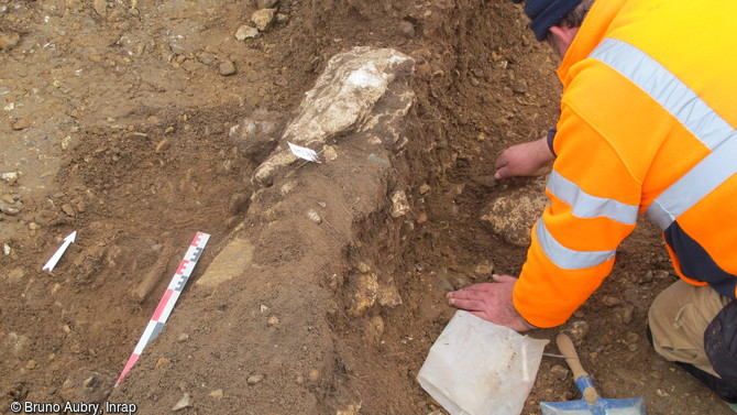 Dégagement partiel d'une inhumation marquée par un empierrement de calcaire et de silex à Cléon (Seine-Maritime), 2016. Elle pourrait se rattacher à l'âge du Bronze.