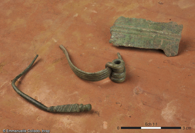 Epingle (à gauche) et fibules en alliage cuivreux découverts dans les thermes de Langrolay-sur-Rance (Côtes-d'Armor), 2016.