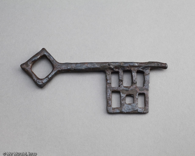 Clé en fer, à tige bénarde à anneau carré et paneton ajouré aux pertuis formant grille, XIe-XIVe siècle, longueur 10,7 cm, mise au jour dans une sépulture de l'ancien prieuré de la Madeleine sur le site du Pont de l'Europe à Orléans (Loiret).