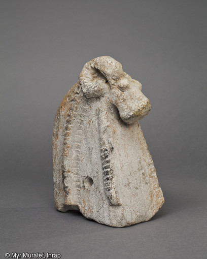Fragment de chenet en forme de tête de bélier, terre cuite, 1er-IIIe siècle, découvert au n° 18 de la rue Porte Saint-Jean à Orléans (Loiret). Comme pour la période gauloise, les chenets en terre cuite sont souvent couronnés d'une tête de bélier. 
