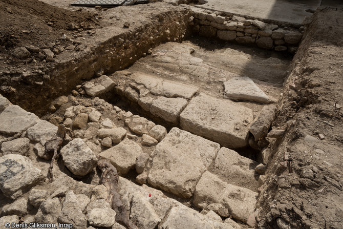 Une chaussée dallée antique équipée d'un caniveau borde le bâtiment à la mosaïque antique découverte à Uzès (Gard), 2017.