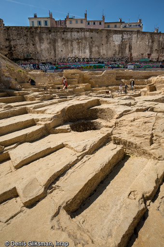 Négatifs de blocs dans la carrière grecque archaïque à Marseille (Bouches-du-Rhône). Ces blocs longs et étroits peuvent correspondre à des linteaux, marches d'escalier...ou autres usages. Au centre du cliché, un puits ou citerne moderne creusé dans le rocher.