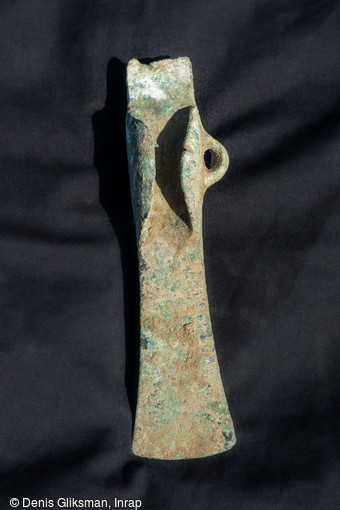 Hache à ailerons du Bronze final découvert dans la fosse du dépôt d'objets métalliques au cours de la fouille sur le Mont Castel à Port-en-Bessin (Calvados)