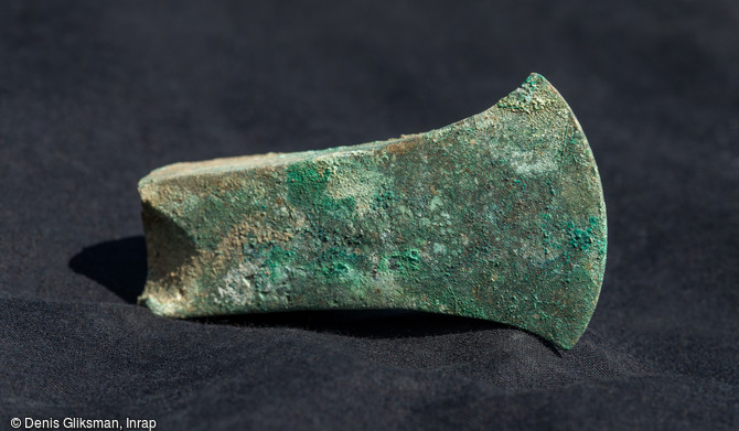   Fragment distal d'une hache à aileron du Bronze final découvert dans la fosse du dépôt d'objets métalliques au cours de la fouille sur le Mont Castel à Port-en-Bessin (Calvados)    