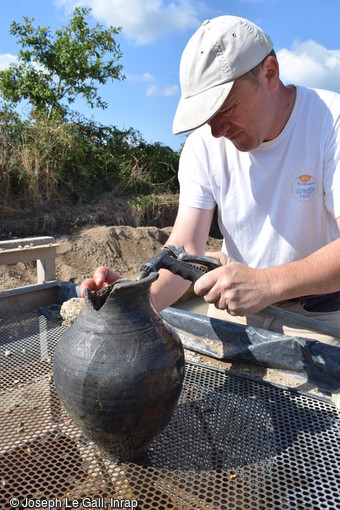 Nettoyage d'un vase de la fin de l'Antiquité mis au jour dans le comblement d'un puits associé au second habitat gallo-romain sur le site archéologique de la Zac de Brestivan à Theix-Noyalo (Morbihan).