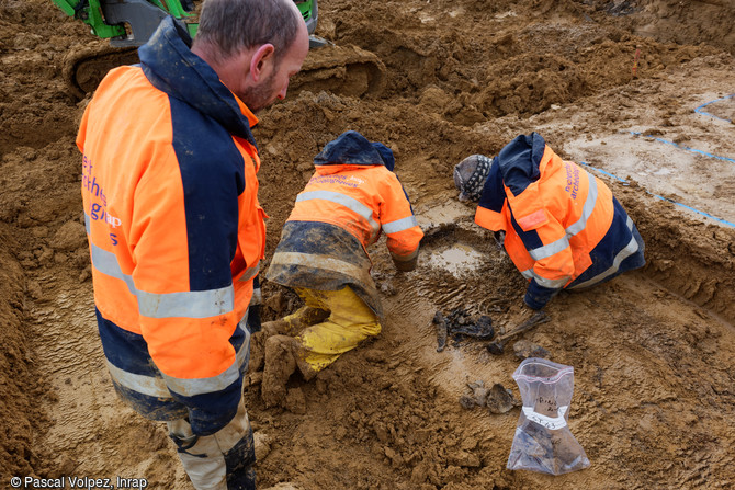 Fond d'un ossuaire en cours de fouille sur le site de la nécropole provisoire de la Grande Guerre à Spincourt (Meuse). Quelques os et éléments d'uniforme d'un défunt sont encore là.