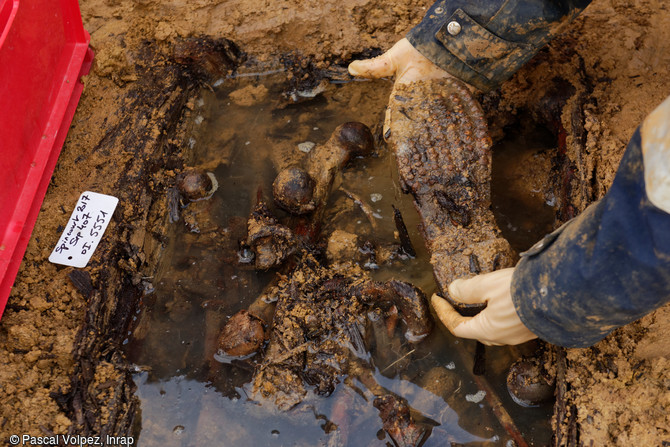 Prélèvement d'une chaussure de soldat dans l'un des ossuaires d'une importante fosse multiple sur le site de la nécropole provisoire de la Grande Guerre à Spincourt (Meuse).