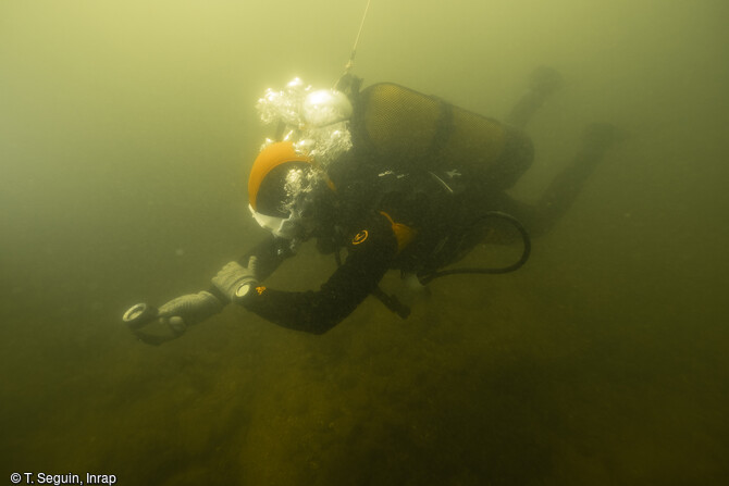 Un plongeur archéologue se dirige à la boussole pour réaliser une prospection dans le Lot à Saint-Vite.