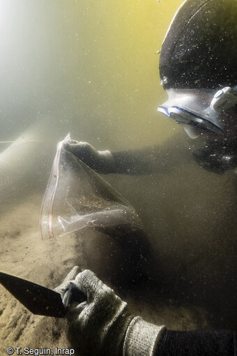 Dans le lac de Sanguinet, un plongeur effectue des prélèvements dans un sondage pour une analyse sédimentaire et une possible datation C14.
