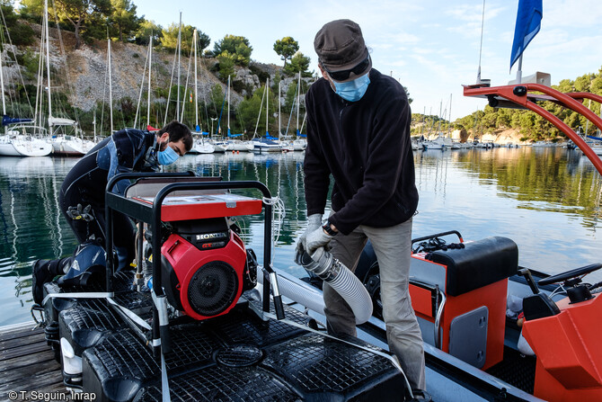 La motopompe haute pression qui alimente les aspirateurs à sédiments est attachée solidement sur le ponton avant sa mise à l'eau dans la calanque de Port-Miou.