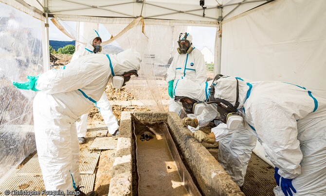 Découverte de la sépulture après l'ouverture du cercueil en plomb présumé hermétique sur le chantier de fouille de la nécropole de l'Antiquité tardive à Autun (Saône-et-Loire) en 2020. Dans un espace clos aménagé, l'équipe munie de masques et de combinaisons intégrales, pour se prémunir contre toutes formes de contamination, était constituée d'un anthropologue, un paléo-épidémiologiste, un carpologue, un archéologue en charge du mobilier, une restauratrice, et de deux spécialistes de la photogrammétrie et des tissus.