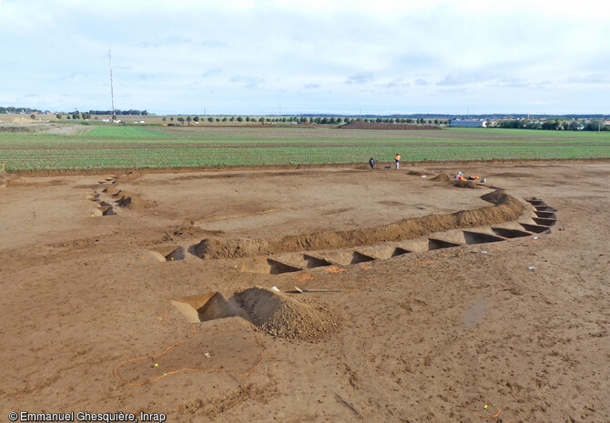 Enclos de l’âge du Bronze ancien, contemporain de la tombe princière et des groupes funéraires trouvés sur les sites de Giberville et Colombelles (Calvados) en 2020.  Dans ses fossés ont été retrouvés des témoins mobiliers de l’activité domestique de la période (faune domestique consommée, divers récipients céramiques, outils de mouture et outils en silex).