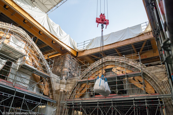  Évacuation des déblais de la fouille de la croisée du transept de la cathédrale Notre-Dame de Paris par grutage, en 2022.  Son sol a révélé des vestiges d’une qualité scientifique remarquable et notamment un sarcophage gothique en plomb anthropomorphe et des éléments du jubé médiéval (mur de clôture qui séparait le cœur et la nef) détruit au début du XVIIIe s. 