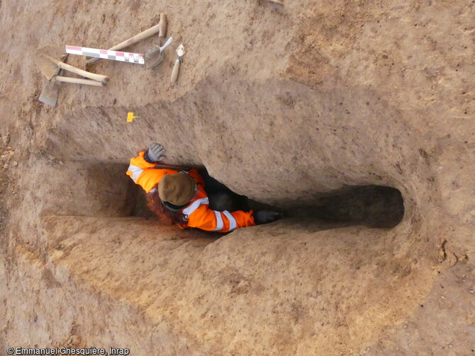 Fouille d'une fosse de chasse de type Schlitzgrüben à Giberville (Calvados) en 2020. Leur usage pourrait remonter à une période comprise entre le début du Néolithique et l'âge du Bronze final (entre 5000 et 1000 ans avant notre ère). Son profil en Y, avec une partie étroite et profonde, servait à piéger les pattes des grands mammifères (Cerfs, aurochs, chevreuils et sangliers). Sur le site, la moitié d'entre elles sont alignées sur 120 mètres, créant ainsi un système de piège étendu. L'archéologue est ici accroupi dans une fosse de moins d'1m de profondeur. 