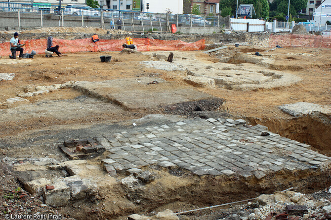 L'ancienne gare du Pecq (Yvelines) en cours de fouille en 2017. Partie ouest de l'emprise de la fouille. Au premier plan, les pavés de l'aménagement du XXe siècle, les plaques de retournement des locomotives à l'arrière plan. 