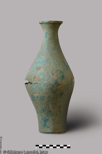 Vase en bronze de 6,8 kg, contenant un trésor monétaire, le col est obstrué par du tissu. Il a été découvert dans les fondations d'un bâtiment rectangulaire d'époque romaine à Saint-Sauveur (Somme) en 2021. 