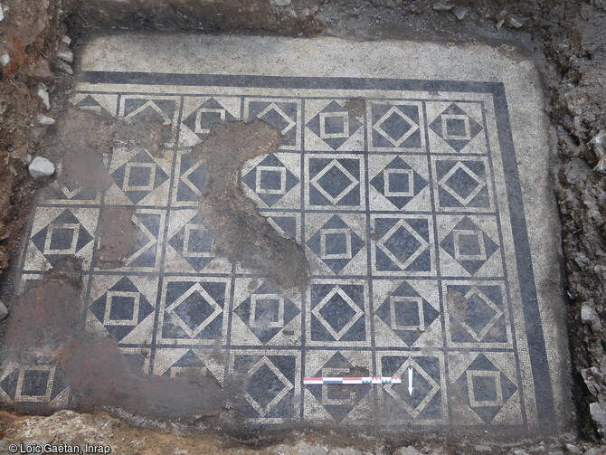 Vue générale de la mosaïque de la pièce centrale de la villa gallo-romaine mise au jour lors d'un sondage du corps de ferme du château de Marigny à Fleurville (Saône-et-Loire). Cette pièce correspond sans doute à une grande salle de réception de 136m2. Le décor géométrique en bichromie noir et blanc est composé d'un quadrillage de cases entourées d'un filet noir et chargées de carrés alternativement droits et sur la pointe. D'après leur style elle pourrait datée de la fin du 1er siècle. 