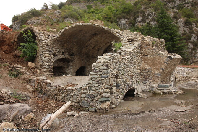 Le moulin bas tel qu'il apparait après débroussaillage à Saorge (Alpes-Maritimes). Il est adossé au moulin haut à gauche, et au pont à droite. Le fleuve en crue l'a traversé de part en part, des pans entiers de murs ayant été retrouvés sous la couche de sable qui l'a envahi. 