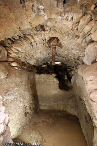 Vestiges du mécanisme d'entrainement d'un des moulins mis au jour lors de la fouille à Saorge (Alpes-Maritimes). La chambre des eaux sous les meules en place. La bassègue qui dépasse sous la voûte a perdu son embase ainsi que sa roue à godets. Le canal d'amené, au fond n'est pas étanche. A l'intérieur se trouvait une canalisation en bois, l'abée.