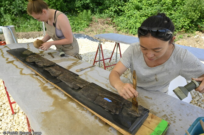 Lavage d'un élément du plancher de l'épave du bateau du haut Moyen Âge (VIIe-VIIIe siècles) découverte à Villenave-d'Ornon (Gironde) en 2022. La présence d'un plancher indique que cette embarcation pouvait transporter des marchandises en vrac. 