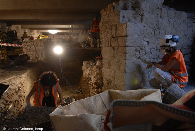 Archéologues durant la fouille du fossé de la porte Pairolière médiévale à Nice (Alpes-Maritimes) sous la dalle de couverture en 2007. 
