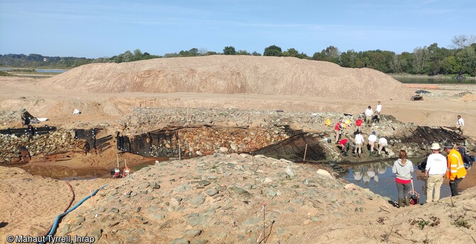 Fouille des épaves des XVIIe-XVIIIe siècles dans la partie amont de l'île Coton, Ancenis (Loire-Atlantique) en 2022. Elles reposent sous et autour de  longues structures empierrées.